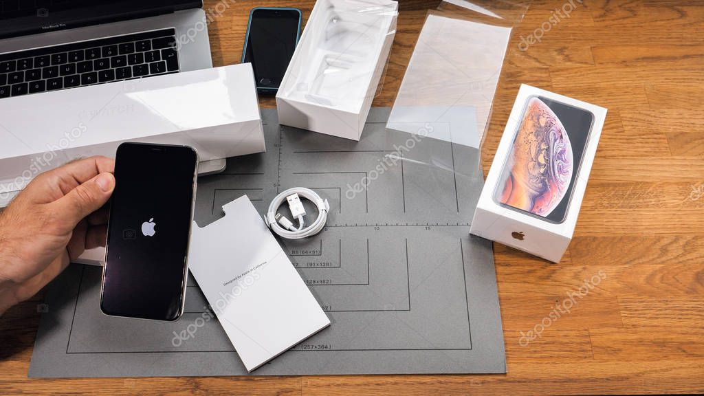 PARIS, FRANCE - SEPTEMBER 21, 2018: Apple fan boy unboxing latest new Apple Iphone Xs Max and Xs flagship smartphone mobile phone model from Apple Computers first run of phone with Apple Logo on