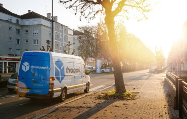 Strasbourg Fransa - 19 Aralık 2016: Beyaz mavi Dpd La Poste teslim kamyonlarının sabahın erken saatlerinde güneşli Caddesi üzerinde şehir merkezinde üzerinden. Chronopost ve Dpd parçasıdır Fransız grup La poste