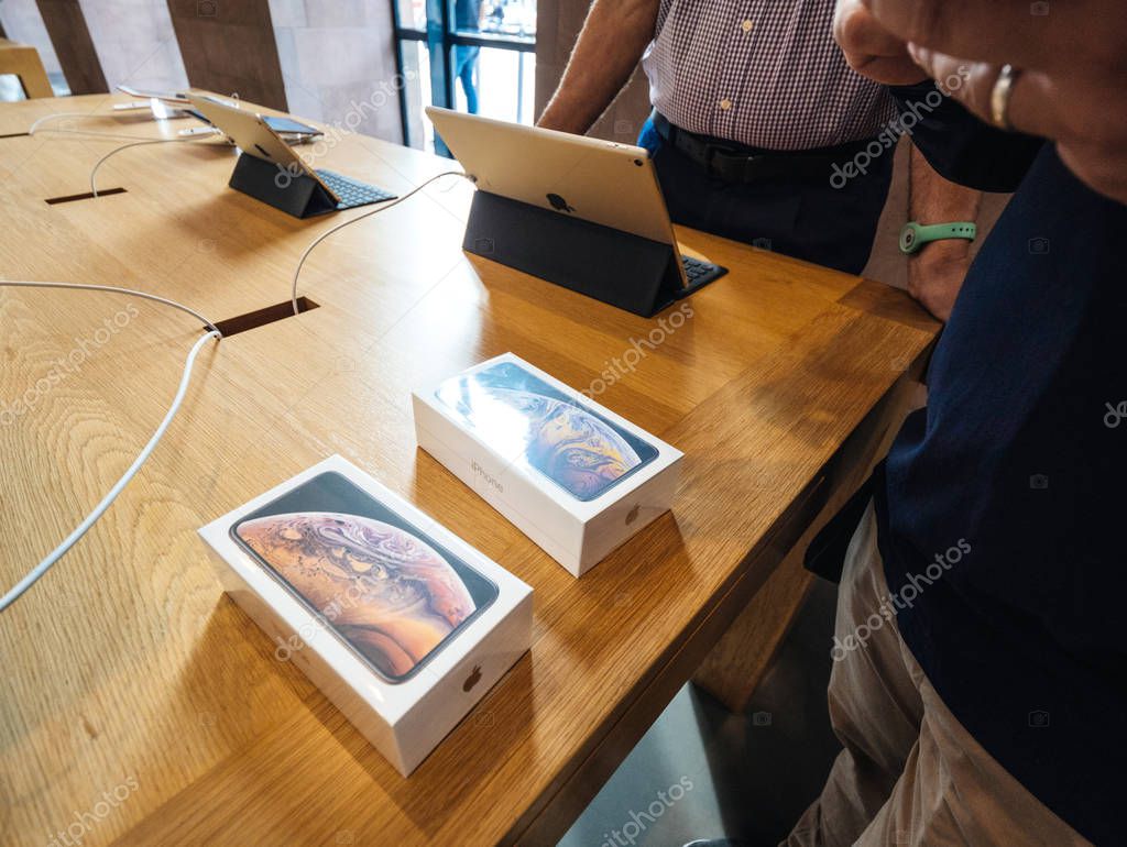 STRASBOURG, FRANCE - SEP 21, 2018: Apple Store with Genius seller-man hands near two iPhone Xs and Xs Max during the launch day