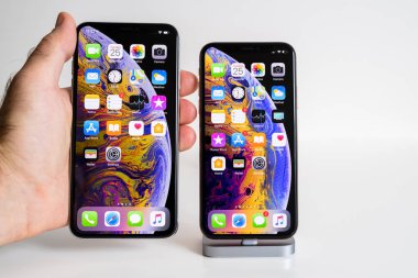 Paris, Fransa - 25 Eylül, 2018: Erkek el karşılaştırmak yeni iphone Xs ve Xs Max smartphone modeli Apple bilgisayarlar tarafından büyük Max bir birden çok apps yer tutan el ile kapatın