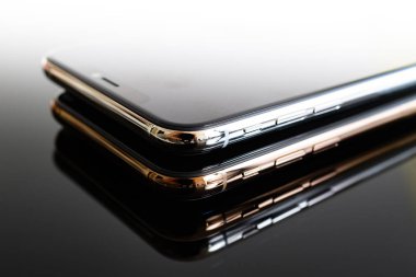 Paris, Fransa - 25 Eylül, 2018: Başka bir iphone Xs ve Xs Max smartphone modeli Apple bilgisayarlar tarafından yukarıda yakın çekim yeni altın gümüş iphone hareket eden telefon aygıt gri yansıtıcı arka plan üzerinde