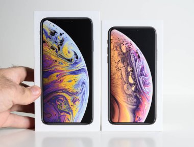 Paris, Fransa - 25 Eylül, 2018: beyaz arka plan el karşı Apple bilgisayarlar tarafından smartphone modelinin unboxing önce yeni iphone Xs ve Xs Max karton kutu karşılaştırmak daha büyük Max sürümü seçin