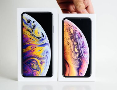 Paris, Fransa - 25 Eylül, 2018: akıllı telefon Xs küçük sürümünü seçme beyaz arka plan karşı unboxing önce yeni iphone Xs ve Xs Max karton kutu sunan adam ellerini karşılaştırın