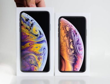 Paris, Fransa - 25 Eylül, 2018: Dostum yeni iphone Xs ve Xs Max karton kutu sunan eller akıllı telefon Xs Max sürümünü seçme beyaz arka plan karşı unboxing önce karşılaştırın