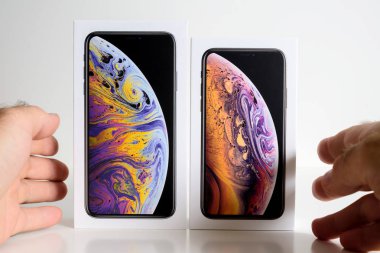 Paris, Fransa - 25 Eylül, 2018: yeni iphone Xs ve Xs Max karton kutu arasında seçim yapma adam ellerini beyaz arka plan karşı Apple bilgisayarlar tarafından smartphone modelinin unboxing önce karşılaştırın