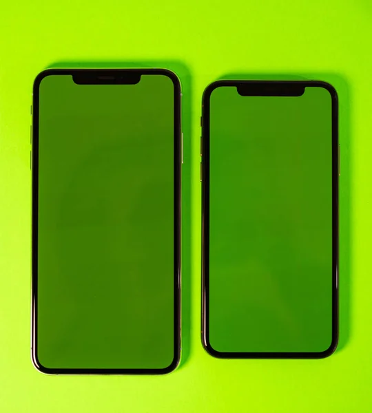 Smartphone-Telefon vor leuchtendem grünen Hintergrund — Stockfoto