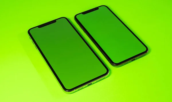 Смартфон телефон на ярком зеленом фоне — стоковое фото