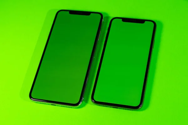 Смартфон телефон на ярком зеленом фоне — стоковое фото