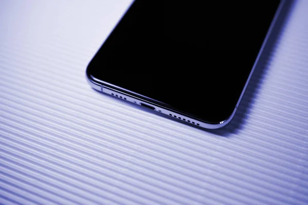 New iphone Xs against stripe background lighting port — Stock Photo, Image