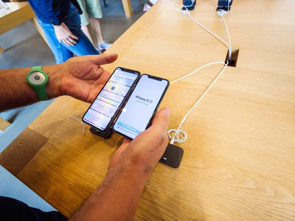 Hombre mayor que compara los últimos teléfonos inteligentes iPhone Xs — Foto de Stock