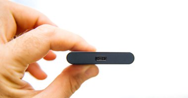 Adam el taşınabilir Ssd 2 tb harici sabit tutarak yüksek okuma ile yuvarlak yüzey götürmek ve karşı yeşil arka plan unboxing testi - hız usb-c yıldırım bağlantıdaki - beyaz arka plan arıyor yazmak 
