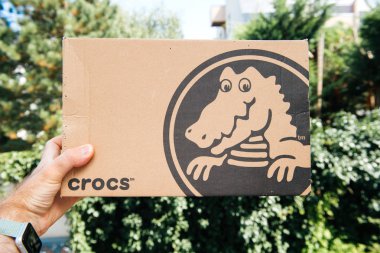 Paris, Fransa - 23 Ocak 2018: yeni çift Crocs tarafından yeni ayakkabı ile bir karton kutu tutan adam 