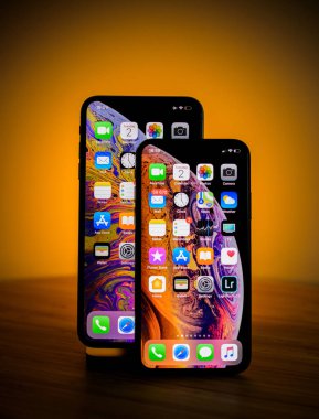 Paris, Fransa - 2 Ekim 2018: İki akıllı Apple bilgisayarlar - iphone Xs ve turuncu arka planda hafif Max'le Xs - spot studio Show
