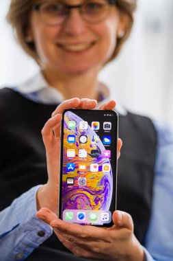 Paris, Fransa - 2 Ekim 2018: Mutlu iş kadın gösteri yeni Apple iPhone Apple bilgisayarlardan Xs Max smartphone telefon Oled ekran üzerinde tüm ev apps ile