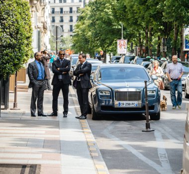 Paris, Fransa - 21 Mayıs 2016: Sürücüleri ve George V lüks hotel Paris önünde park edilmiş zarif Rolls Royce araba yakınındaki konuşurken güvenlik personeli