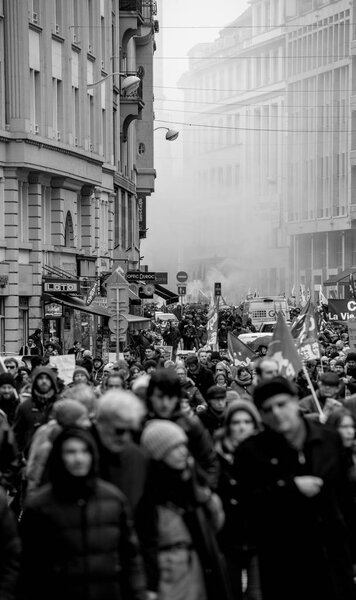 STRASBOURG, FRANCE - MAR 22, 2018: CGT General Confederation of Labour workers with placard at demonstration protest against Macron French government string of reforms - perspective view with smoke