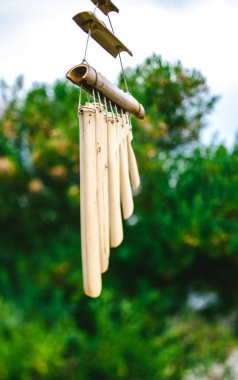 Wooden wind chimes in Japanese garden clipart