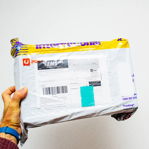 Человек держит посылку Почта Австралии — стоковое фото