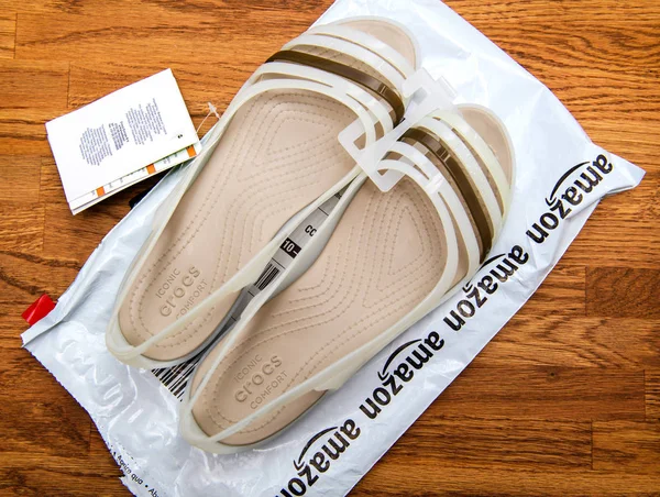 Homem segurando sapatos Crocsh para mulheres — Fotografia de Stock