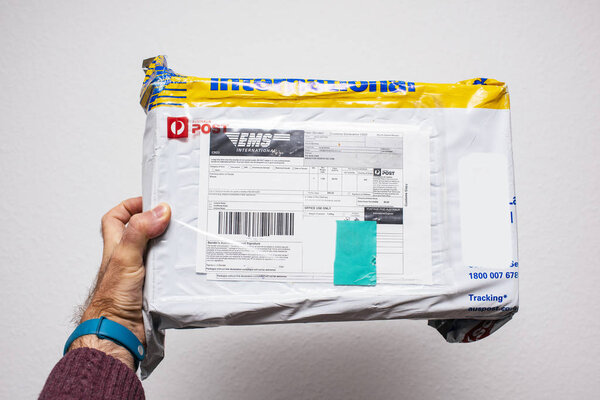 Человек держит посылку Почта Австралии
