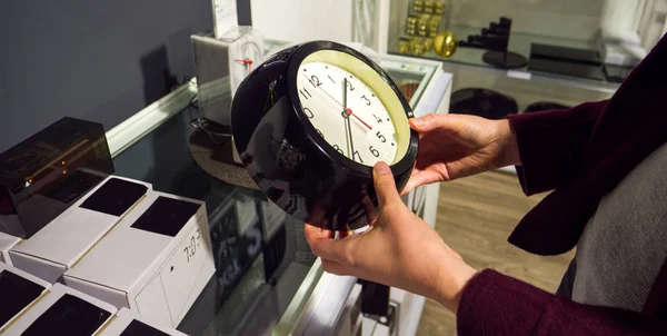 Woman buy wall clock in furniture shop — Stock Photo, Image