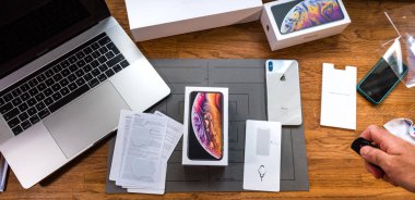 Man unboxing iPhone Xs Max Xr reading manual clipart