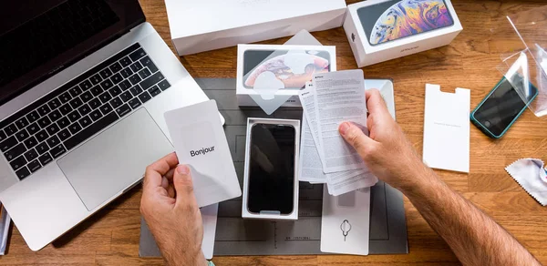 Człowiek unboxing iphone Xs na office tabela — Zdjęcie stockowe