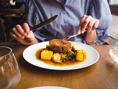 Polenta ile kuzu eti yiyen kadın