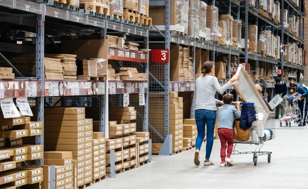 Mãe solteira fazendo compras na loja de móveis IKEA empurrando carrinho — Fotografia de Stock