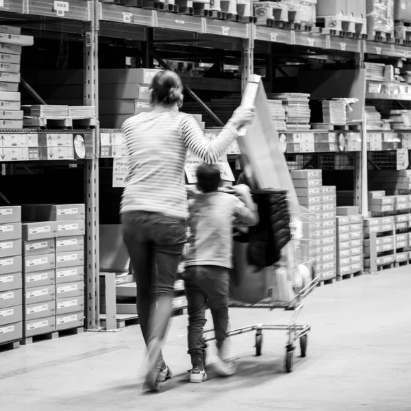 Mãe solteira fazendo compras na loja de móveis IKEA empurrando carrinho — Fotografia de Stock