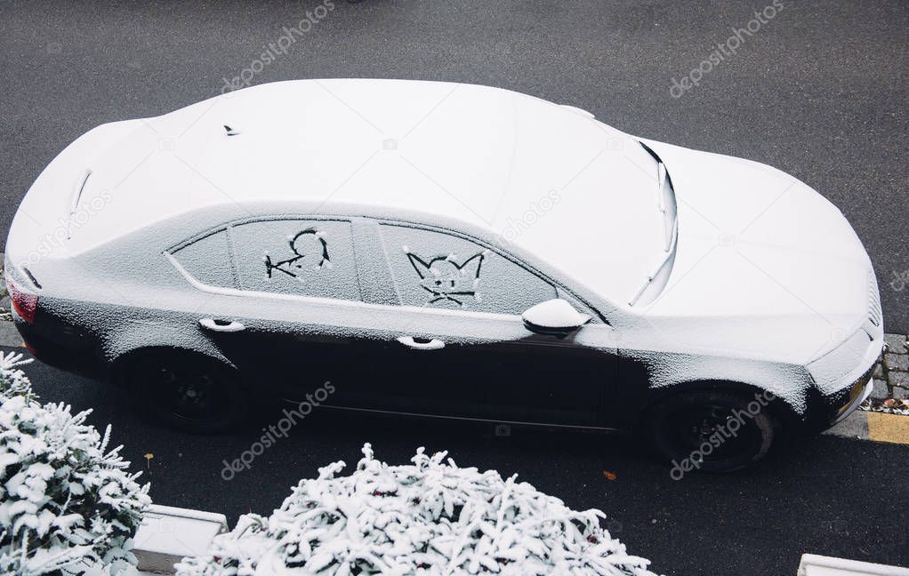 Car covered with snow with cat am mouse silhouettes