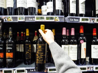 Strasbourg, Fransa - 30 Aralık 2017: kırmızı şarap alkollü içki şarap, şampanya ve viski şarap bölümü büyük bir Fransız süpermarket satın alma Pov kadın