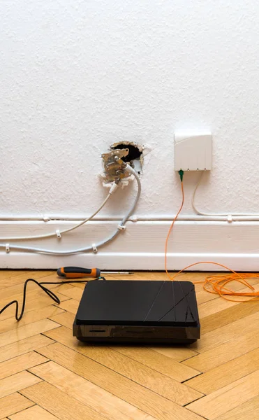 在家用墙壁上安装光纤 配有过时的 Catv 和新的 Ftth 光纤插座和镶木地板上的互联网接收器 — 图库照片