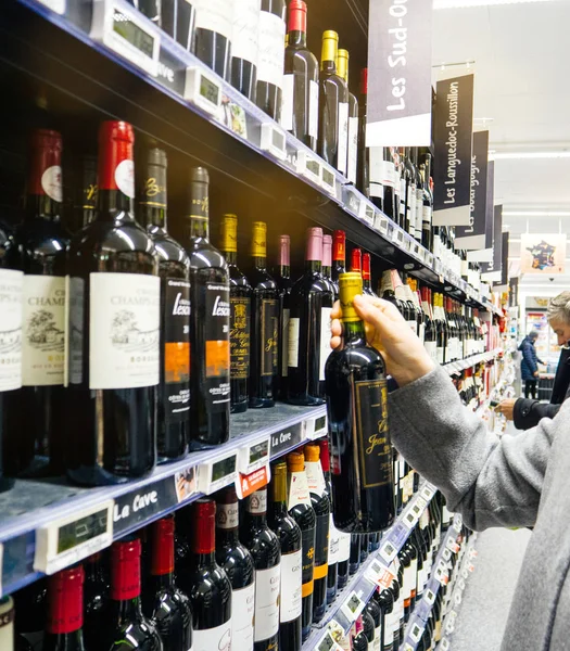 法国斯特拉斯堡 2017年12月30日 优雅的法国妇女在一家法国大型超市的葡萄酒部门购买红酒 葡萄酒 葡萄酒和威士忌 — 图库照片