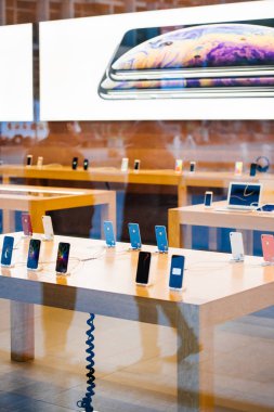 STRASBOURG, FRANCE - OCT 26, 2018: Table with mutiple latest iPhone XR smartphone in Apple Store Computers during the launch day - view from the street clipart