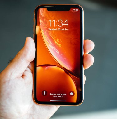 Strasbourg, Fransa - 26 Ekim 2018: Mutlu sahibi Pov holding yeni kırmızı iphone Xr smartphone denize indirmek gün hayran sırasında kırmızı duvar kağıdı ev kilit ekran - kare görüntü