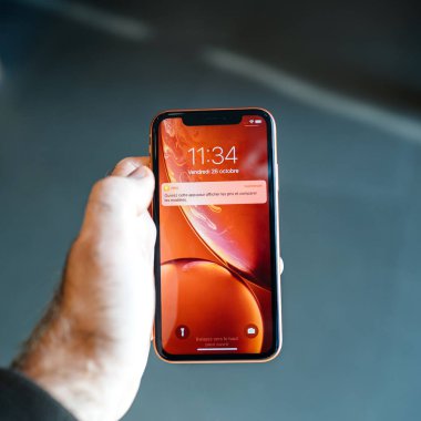 Strasbourg, Fransa - 26 Ekim 2018: Müşteri yeni kırmızı iphone Xr smartphone denize indirmek gün bildirim fiyat uygulaması sırasında holding Pov