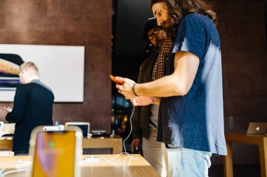 Paris, Fransa - 26 Ekim 2018: Apple Store kırmızı renkli dikey görüntü seçerek yeni en son iphone Xr smartphone telefon - hayran iki genç hippi erkek müşteriler ile
