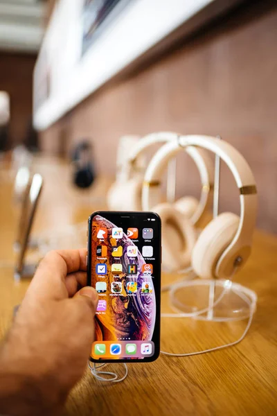 法国巴黎 2018年10月26日 人手持新的 Iphone Max 与苹果音乐应用程序和多个无线蓝牙耳机节拍博士 Dre Studio 垂直图像 — 图库照片