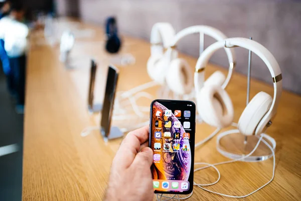 法国巴黎 2018年10月26日 男子手持新的 Iphone Max 与苹果音乐应用程序和多个无线蓝牙耳机节拍博士 Dre Studio — 图库照片