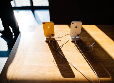 Paris, Fransa - 26 Ekim 2018: Görünümünü yukarıda sarı ve beyaz yeni iphone Xr akıllı telefon Apple Store bilgisayarlar uzun gölge ile denize indirmek gün boyunca ahşap masa yatay görüntü üzerinde