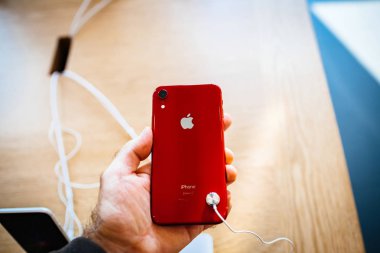 Paris, Fransa - 26 Ekim 2018: denize indirmek gün - cam logo ile arka sırasında kırmızı yeni iphone Xr akıllı telefon Apple bilgisayarlardan tutan adam Pov el