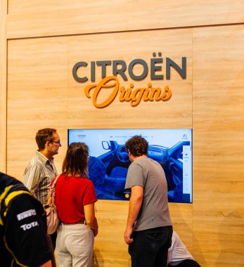 PARIS, FRANCE - OCT 4, 2018: People discovering at digital AR screen more information about car configurations and Citroen Origins - car stand at International car exhibition Mondial Paris Motor Show  clipart