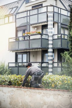 Arkadan Görünüş bahçıvan kesme çalılar ve ağaçlar ile modern Fransız apartmanın arka planda kontrol