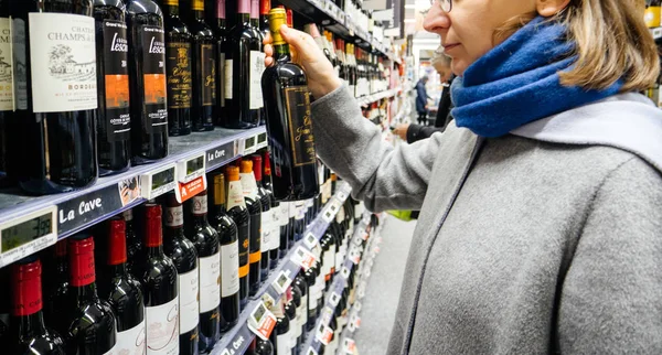 法国斯特拉斯堡 2017年12月30日 优雅的法国妇女在一家法国大型超市的葡萄酒部门购买各种酒精饮料 葡萄酒和威士忌 — 图库照片