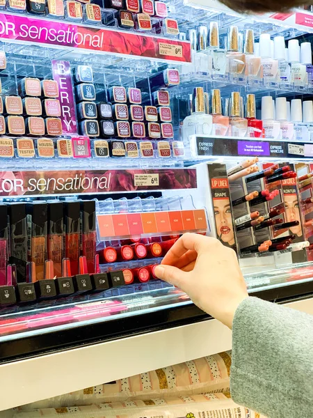 Mujer comprando lápiz labial rojo — Foto de Stock