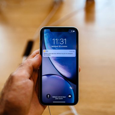 Paris, Fransa - 26 Ekim 2018: en son mavi iphone Xr smartphone denize indirmek gün pov, yeni smartphone ile sıvı Retina dikey sırasında Apple Store Computers'ta tutan adam el