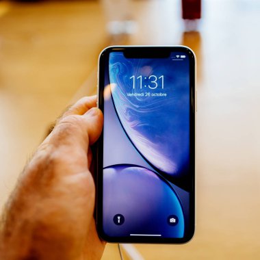 Paris, Fransa - 26 Ekim 2018: en son mavi iphone Xr smartphone denize indirmek gün pov, yeni smartphone ile sıvı Retina dikey sırasında Apple Store Computers'ta tutan adam el
