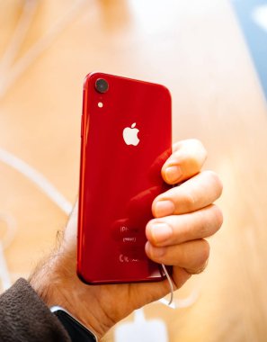 Paris, Fransa - 26 Ekim 2018: logo ile denize indirmek gün arka sırasında kırmızı yeni iphone Xr akıllı telefon Apple bilgisayarlardan tutan adam Pov el