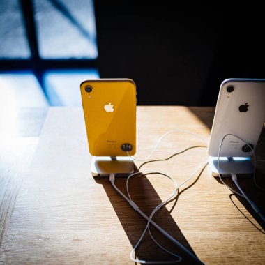Paris, Fransa - 26 Ekim 2018: Görünüm yukarıdan sarı ve beyaz yeni iphone Xr akıllı telefon Apple Store bilgisayarlarda uzun gölge ile denize indirmek gün boyunca Ahşap Masa - kare görüntü